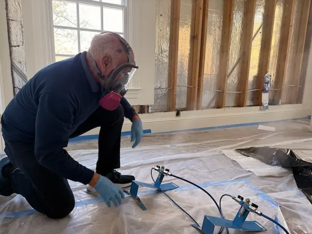 A restoration technician setting drying equipment in a Phoenix home stripped to the studs